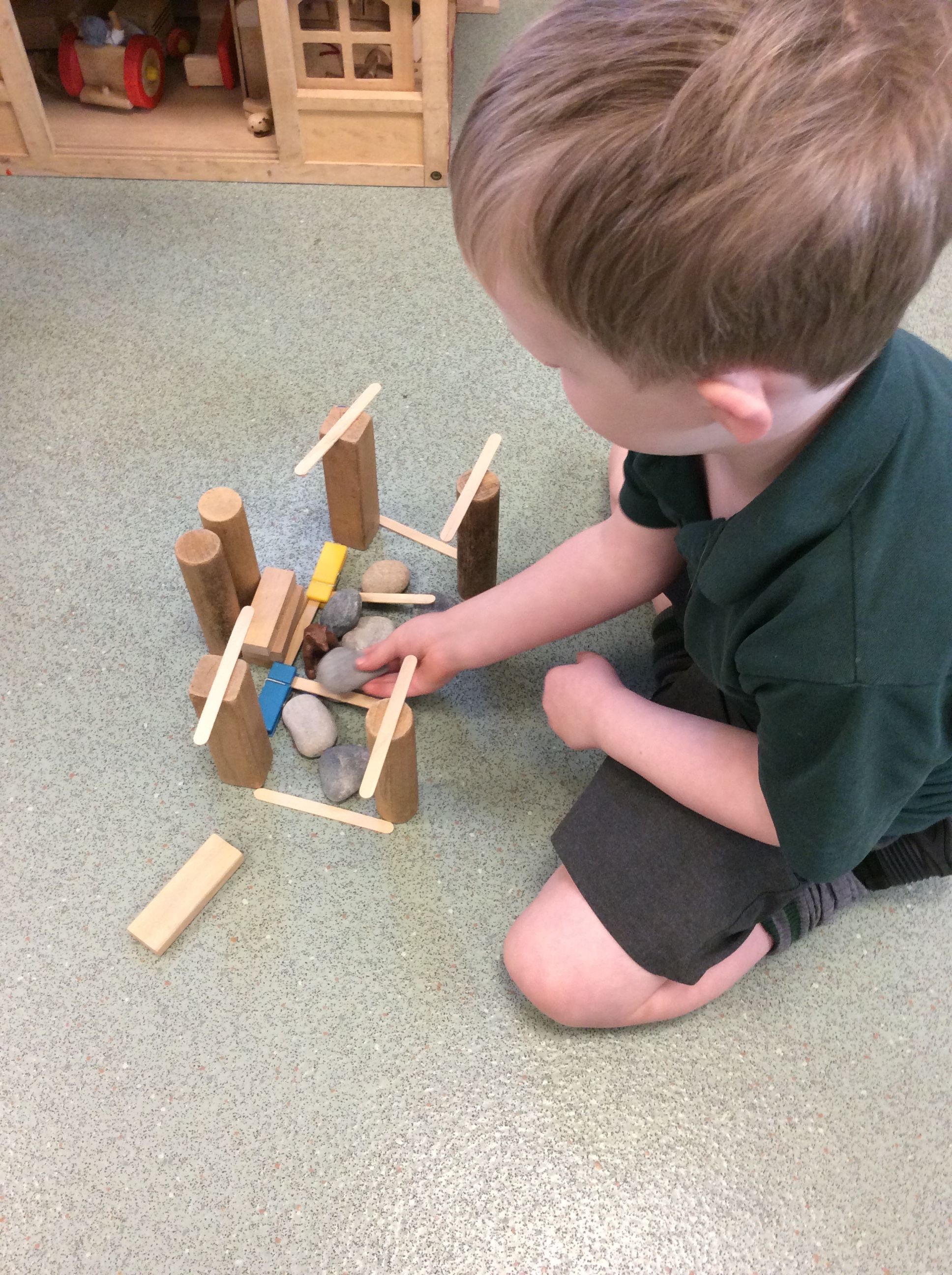 boy building a pen with bricks and animals