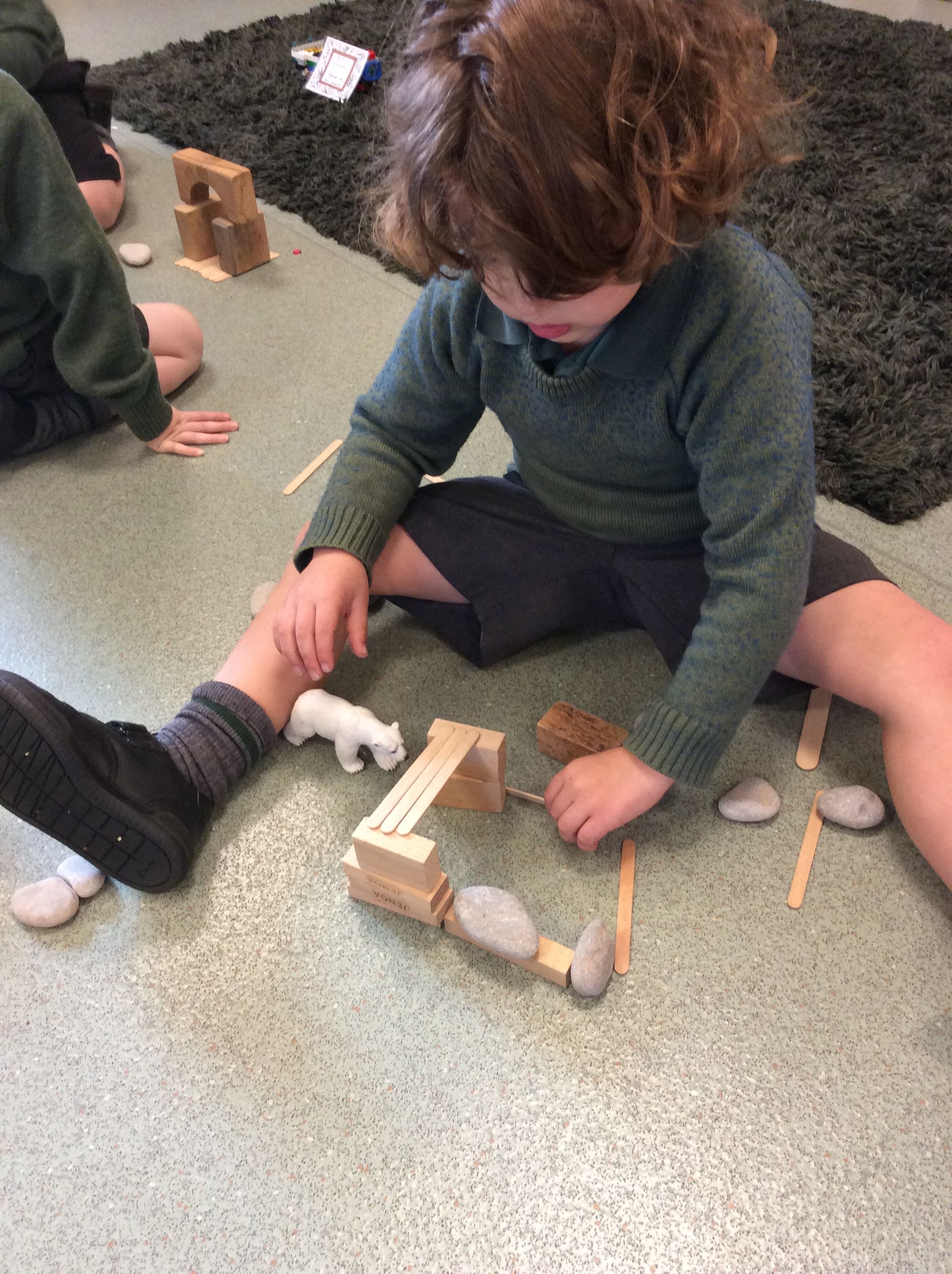 boy building a pen with bricks and animals